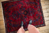 Vintage Lilihan rug, dark raspberry field, sapphire blue floral sprays, pinwheel border, fringe.
