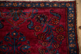 Vintage Lilihan rug's vibrant raspberry field, sapphire blue florals, and pinwheel border.
