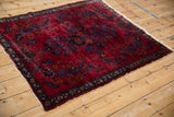 Vintage Lilihan rug corner with sapphire border, rich red floral field, and white fringe.