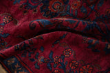 Folded vintage Persian Lilihan rug, showing high gloss raspberry red pile and sapphire floral bouquets.