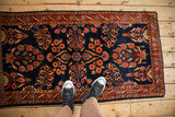 Scale view of an antique Mohajeran Sarouk runner with floral sprays on a navy blue field.