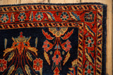 Corner view of an antique Mohajeran Sarouk rug showing the red floral border and deep navy blue field.