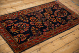 Antique Mohajeran Sarouk runner from an angle, displaying dense floral sprays on a navy blue ground.