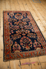 An antique Mohajeran Sarouk runner showing the floral sprays and vines over a cobalt blue field.