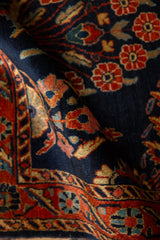 Folded antique Mohajeran Sarouk rug showing the short, dense pile and detailed floral sprays.