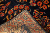 Folded corner of an antique Sarouk rug showing its hand-knotted back and cobalt blue floral pile.