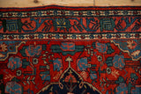 The vintage Bijar's arabesque vine border with floral cross-sections in navy blue, green, and ivory.