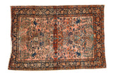 A fine antique Farahan Sarouk rug with scrolling floral arabesques on a faded fuchsia field.