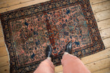 An in-situ view of an antique Farahan Sarouk rug with its faded fuchsia field and intricate medallion.