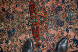 A standing view over the antique Farahan Sarouk's detailed medallion and abrashed field.
