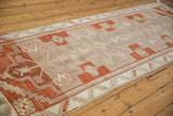 Angled view down the length of a distressed Kars runner showing its repeating geometric medallions.