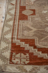 A close view of the Kars rug's serrated leaf border and worn, hand-knotted texture.
