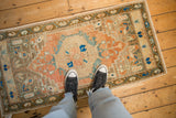 Distressed vintage Oushak runner showing even wear in sandalwood, melon, and blue tones.