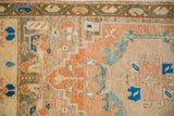 Distressed pile texture and cantaloupe, cobalt blue patterns on vintage Oushak rug.