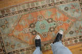 A top-down view showing the distressed texture and even wear of a vintage Oushak rug.