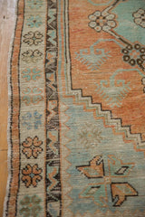Intact side cord selvage alongside floral and geometric serpent borders on a distressed Oushak rug.