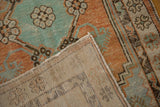 Flipped corner of a vintage Oushak rug reveals its hand-knotted back and secure selvage.