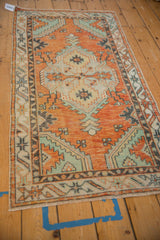 Distressed Oushak runner corner showcasing orange, blue, mint serpent border motif.