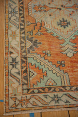 Vintage distressed Oushak runner's geometric border detail in pale orange, mint, and slate blue.
