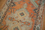 Distressed Oushak rug's serrated floral bouquet in pale burnt orange and mint green.