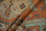 Distressed Oushak runner texture, showcasing burnt orange and mint serrated floral patterns.