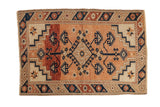 Distressed vintage Dosemealti rug with a hook and latch diamond medallion in copper, navy, and ivory.