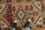 Standing view of a vintage Dosemealti rug, highlighting its worn texture and geometric pattern.