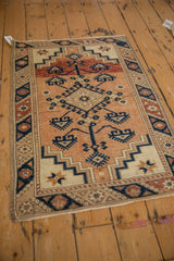 Angled view of a vintage Dosemealti rug showing its full geometric pattern in copper and navy.