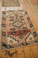 Angled perspective of a vintage Dosemealti rug showing its geometric medallion and copper field.