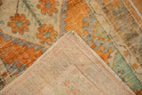Distressed Oushak rug with terracotta and mint motifs, revealing woven foundation.