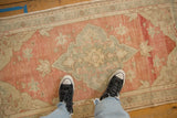 The distressed, low-pile texture of a vintage Oushak rug, showing its real-life scale.