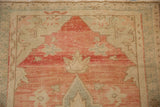 Worn texture of a vintage Turkish Oushak rug with rose, seafoam, and beige knot heads.