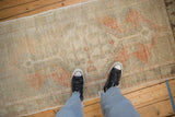 A vintage distressed Oushak runner's soft texture and muted, time-softened colors.