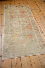 A distressed Turkish Oushak runner viewed at length, showing its time-softened patina.