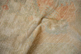 Worn, hand-knotted pile of a vintage Oushak rug with muted sandalwood and sea foam hues.