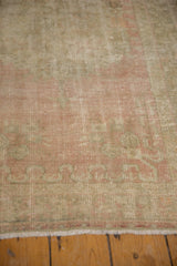 Soft pink, platinum, and silver tones on distressed vintage Oushak rug pile with even wear.