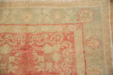 Scrolled corner designs and palmette border of a vintage Oushak runner showing mostly even wear.