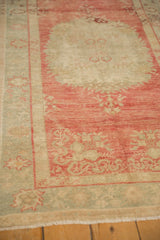 Abrashed raspberry red field and sea foam border of a distressed vintage Oushak rug runner.