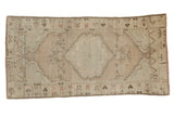 Vintage distressed Oushak runner with a central shield medallion in pale sea foam green and dusty mauve.