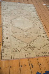 Angled view down the length of a distressed Oushak runner showing its soft patina and worn texture.
