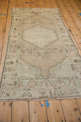 A vintage Oushak runner viewed lengthwise, showcasing its muted palette and low pile.