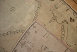 Flipped corner of a distressed Oushak rug showing the hand-knotted foundation and restored side cord.