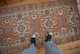 Vintage distressed Oushak runner's arrowed geometric pattern in burnt orange and platinum.
