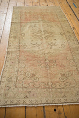 Lengthwise perspective on a vintage distressed Oushak, showing the soft abrashes of dusty rose and ivory.