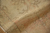 Softly worn pile of a distressed Oushak rug showing texture and faded dusty rose and beige colors.