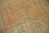 Close-up of the vintage Oushak's distressed low pile and hand-knotted texture.