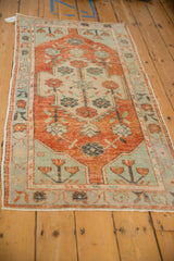 Faded mint green corner spandrel with blossomed flowers on a distressed vintage Oushak rug.