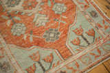 Corner detail of a distressed Oushak rug with mint green and brick red blossomed flowers.