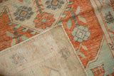 Folded corner of a Turkish Oushak rug showing its hand-knotted foundation and secured side.