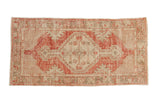 Distressed vintage Oushak rug runner with a stepped medallion in brick red, ivory, and faded silver tones.